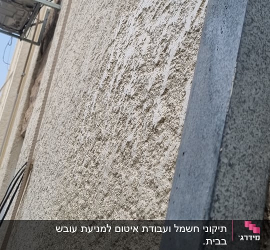קיר טיח עם מזגן חיצוני וצינורות חשמל